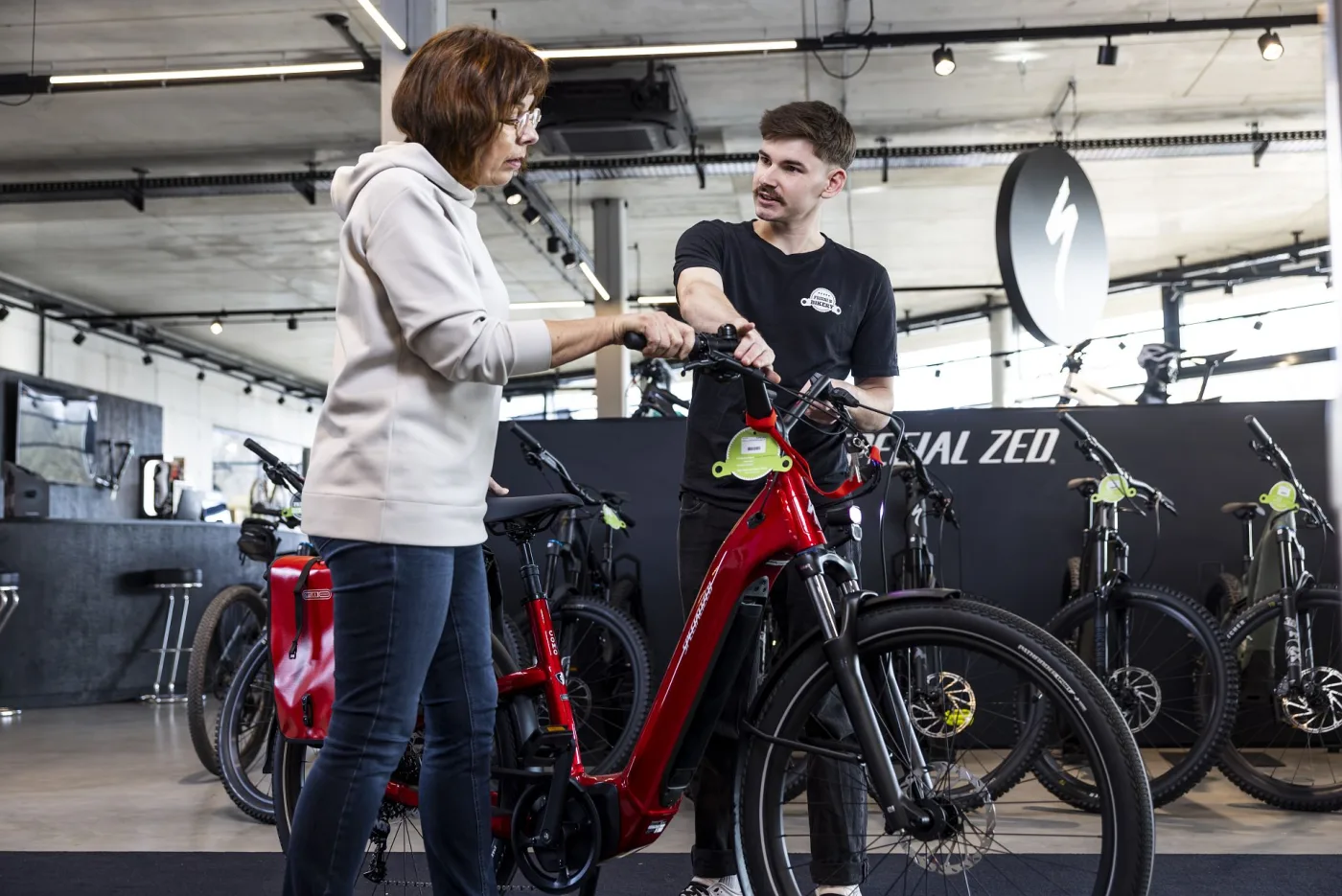 A staff member helping a customer with a new e-bike