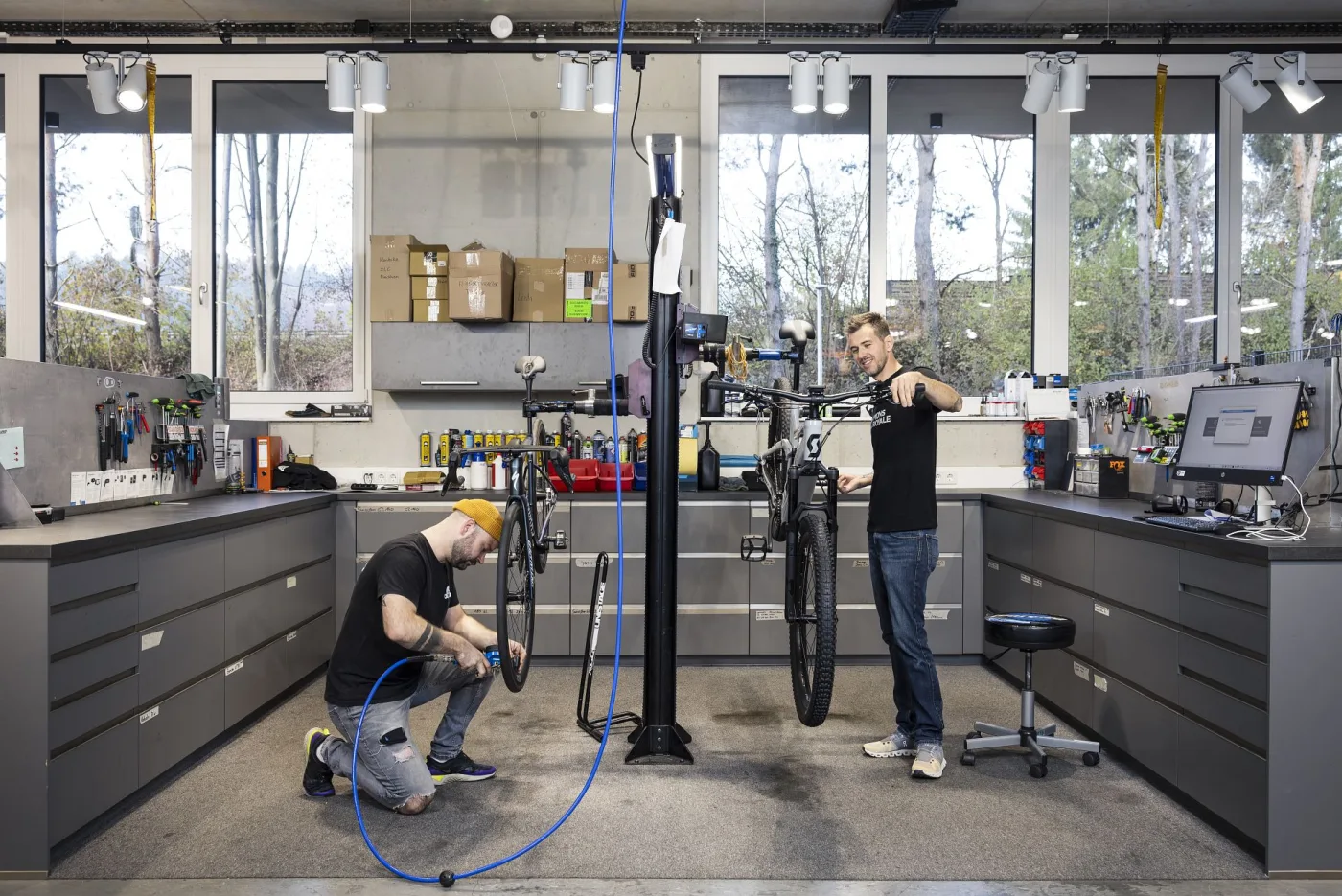 Two mechanics servicing bikes at the workbench
