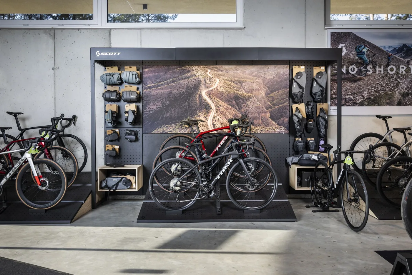 Road bikes and accessories on a retail display wall
