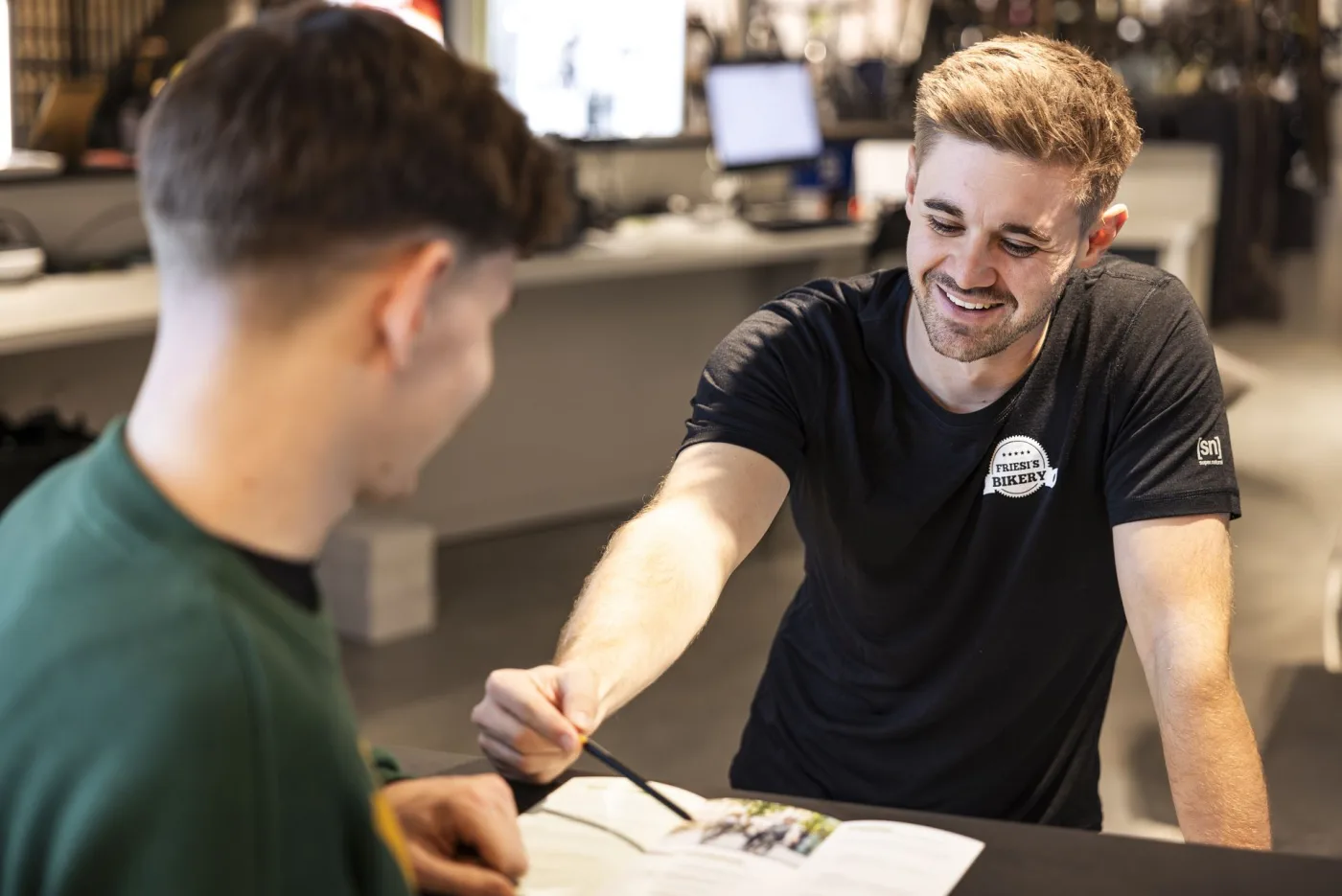A staff member serving a customer at the sales counter