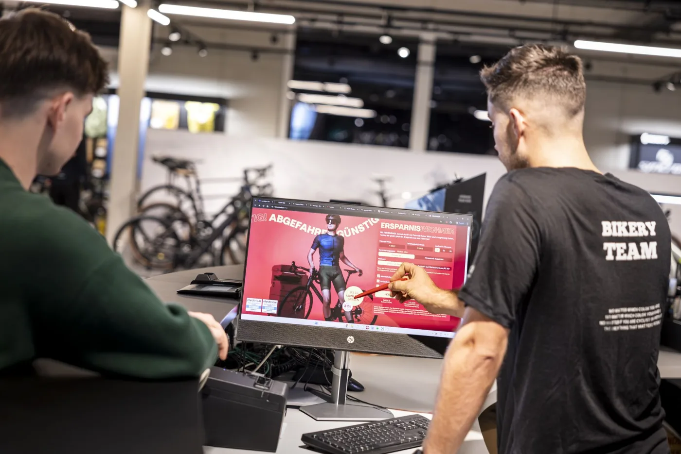 A staff member pointing at software on a monitor