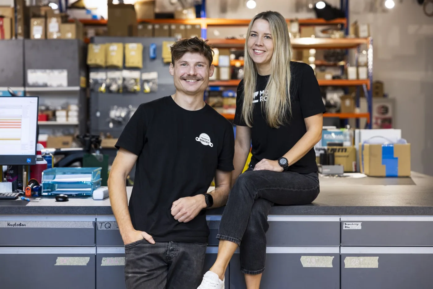 Two staff members at the spare-parts counter in the stockroom